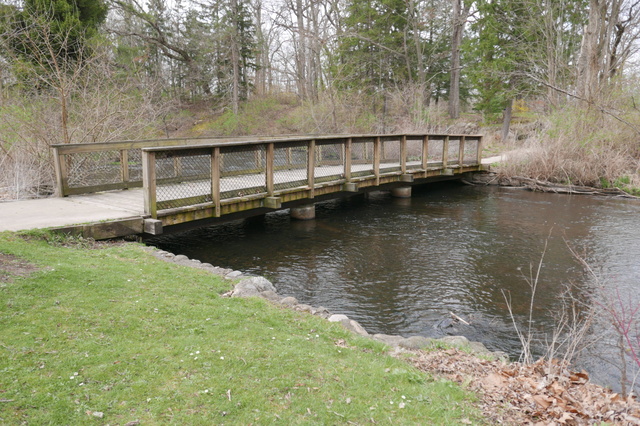 Bridge across Portage River in 49-acre park on a chilly spring day. Had picnic lunch with windbreak under covered shelter. Unproductive visit to city centre, discovered Kalamazoo was practically vacant on Easter Sunday afternoon. (Milham Park, East Kilgore Road, Kalamazoo, Michigan) 20250420 P1070918.JPG